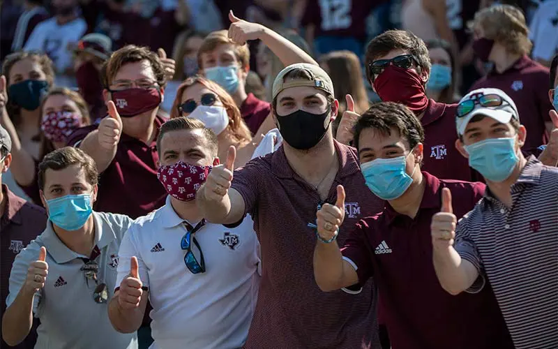 Fans in masks giving thumbs up
