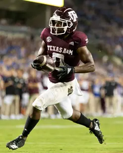 Ainias Smith running with the football on the field during a game