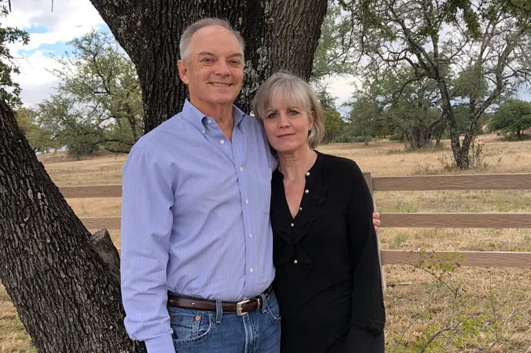 Carla and Rick Moncrief in front of a tree