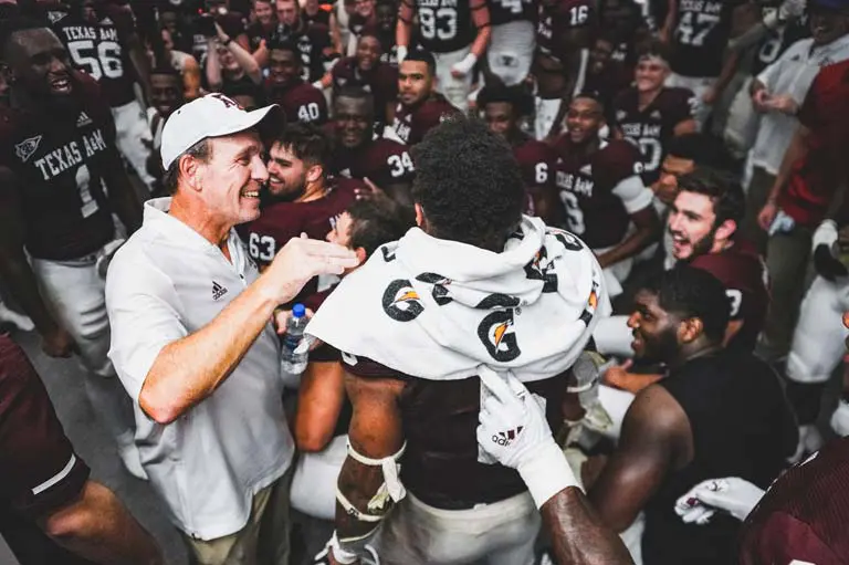 A coach smiling with football players