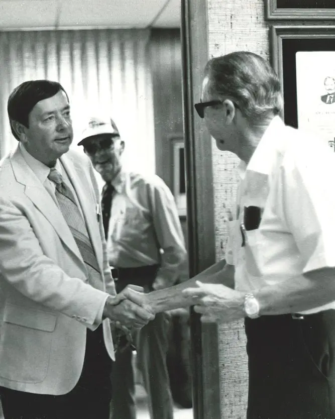 Two Aggie graduates shaking hands