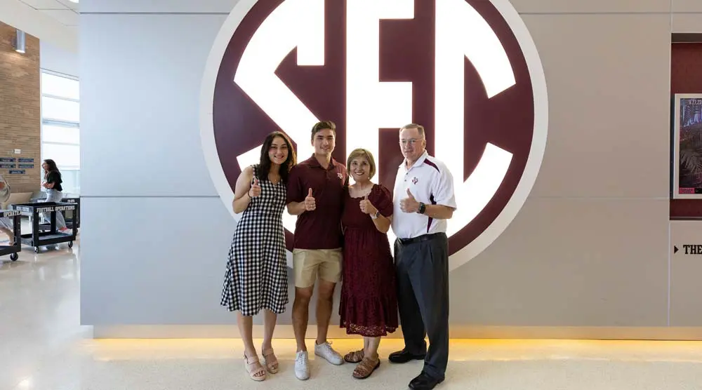 Randy Bond posing in front of SEC sign with family