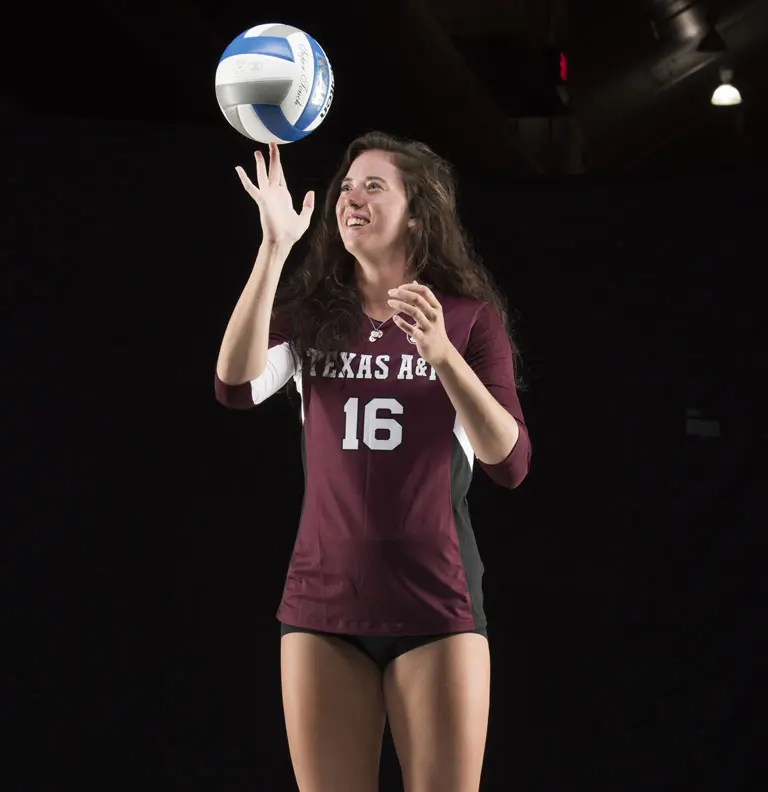 A volleyball player spinning the ball on her finger