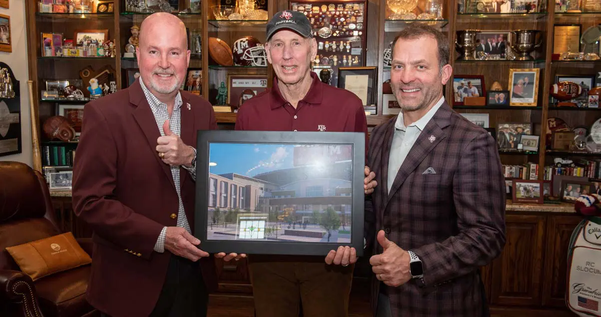 Wayne Roberts with two other men showing a framed photo