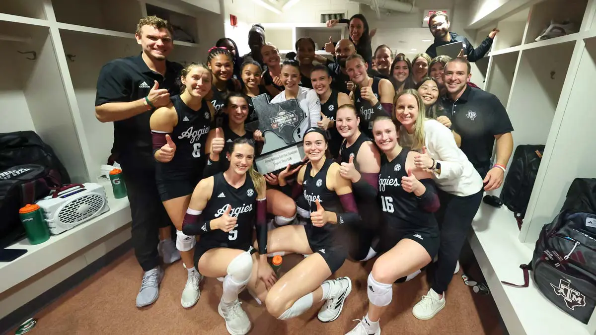 Athletes posing with trophy in locker room